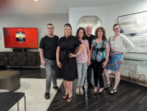 A group of people pose in a luxurious looking living room.